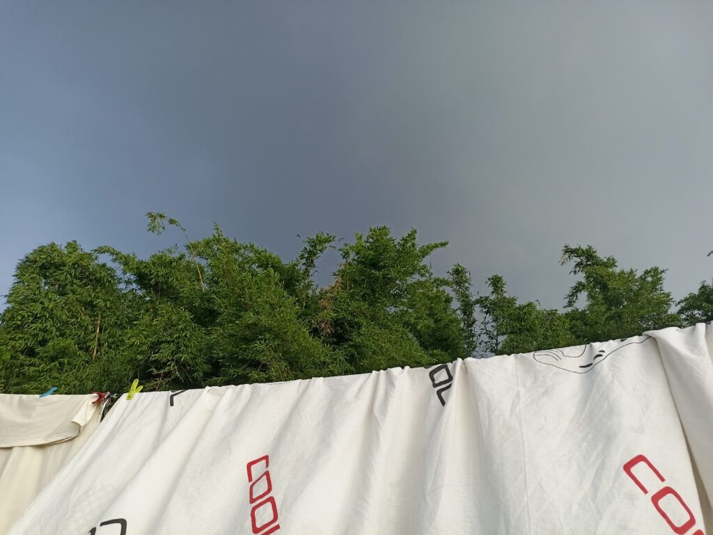 White bedsheet fluttering in a monsoon breeze before expected rainfall.